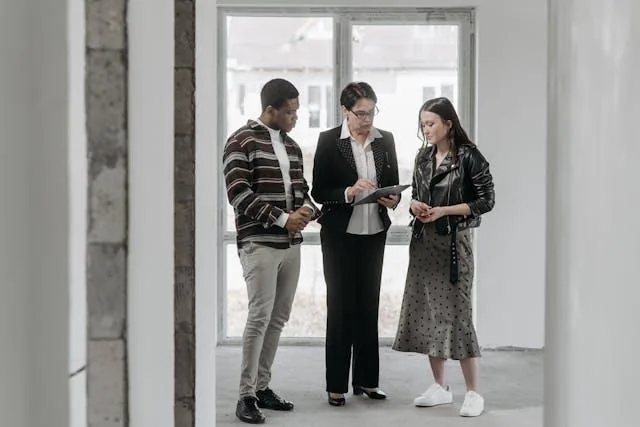 three people talking in an empty rental